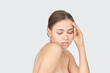 © elenavolf - Young caucasian female with natural makeup posing on neutral background, eyes closed, hand on temple.