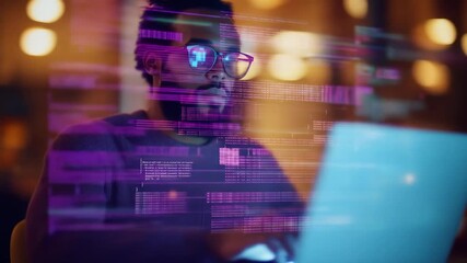 Man working on laptop with virtual data overlay. African american male programmer coding in dark office with holographic interface footage.