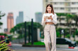 © SpaceOak - Asian Woman Writing in Notebook Outdoors