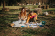 © qunica.com - A couple is creating art together outdoors, with paintings and materials on the grass, fostering creativity and bonding amid natural surroundings and fresh air.