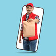 © New Africa - Food delivery service worker giving paper bag out of mobile phone display against light blue background. Online order