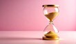 © VisualMinted - Transparent Hourglass with Golden Sand on Soft Baby Pink Background