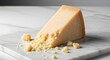 © Rikhy - A gourmet wedge of savory aged hard cheese with crumbles displayed on a white marble cutting board