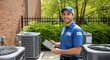 © graphiczone872 - Hvac technician with tablet inspects outdoor air conditioning units on a sunny day