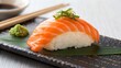 © nurri@rt - Delicious salmon nigiri sushi served on a black plate with wasabi