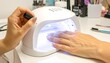 © Joko - Close-up of a hand with manicured nails in a UV lamp for curing gel polish