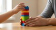 © Langgeng Creation - Child and adult building colorful block tower together.