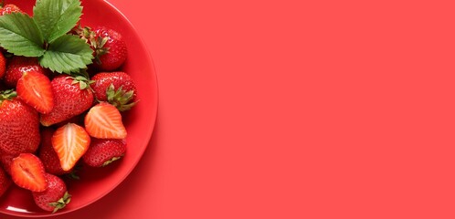 Wall Mural - plate of sweet ripe strawberries on red background with space for text, top view