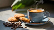 © Soyaeb - A cozy morning coffee break featuring a steaming cup of fresh espresso in a blue ceramic mug, served with sweet biscuits and roasted beans