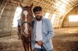 © standret - Man is with horse in the hangar