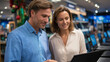 © Kateryna - A man and woman shopping together for a laptop at an electronics store sales assistant pointing at features on the screen bright showroom filled with devices atmosphere of