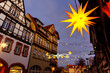 Charming Wernigerode town evening street view illuminated with Christmas lights garlands Herrnhutter stars on historical half-timbered houses facade. Twilight Festive city in Germany