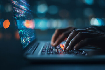 Nighttime coding hands typing on laptop screen glowing with code city lights blurred background