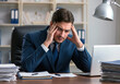 © Ludmila - Stressed mid adult businessman at work with headache