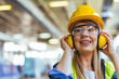 © Dragana Gordic - Female Construction Worker Wearing Safety Gear in an Industrial Setting