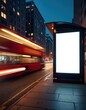 Nighttime street scene with a red double-decker bus in motion and a blank digital advertisement screen at a bus stop. City buildings line the background under a dark blue sky.