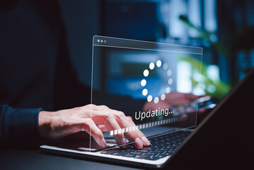 software update and system upgrade concept. person holding phone while using laptop with software up