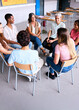 © CarlosBarquero - Vertical. A group of students and a teacher sit in a circle during a school group therapy session, promoting communication, trust and mental health support among teenagers.