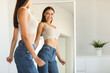 © Prostock-studio - Happy caucasian lady enjoying her reflection in mirror, posing after successful weight loss and smiling, standing near mirror at home. Slimming and dieting concept