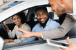 © Prostock-studio - Joyful African Couple Buying New Car Talking With Salesman Testing Auto In Dealership Store. Selective Focus