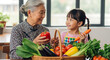 © True Stock - Happy Asian Grandmother and Granddaughter Preparing Healthy Meal with Fresh Vegetables in Kitchen