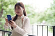 © snowing12 - Asian adult woman freelance work outdoors balcony smartphone digital connection embrace flexible freedom modern life