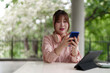 © snowing12 - Asian woman freelancer using smartphone outdoor work remote business browsing internet digital content managing tasks enjoying flexible schedule connected modern lifestyle