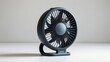 © Ikhsan - A modern, compact, dark gray fan, presented on a plain white surface, creating a clean, minimalist aesthetic.