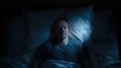© Muara - Man sleeping peacefully in bed with white sheets and pillows, illuminated with blue light from above. Dark shadows surround him, creating a serene atmosphere