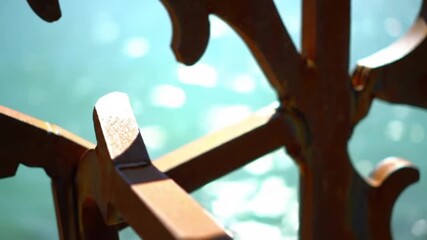 Close up of an ornate metal railing with a blurred blue background of water and bokeh lights behind it