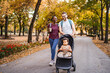 © Jelena - Mixed race couple walks their son's stroller through the park