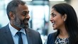 © yang - Two business colleagues engaged in a professional conversation in a modern office environment.