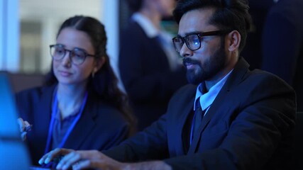 Two IT professionals discuss their AI software project in a tech office. They are collaborating on computer and technology solutions, sharing ideas for the next phase of development.