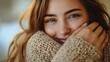 © k - Close-up portrait of a young woman with light brown hair, bright eyes, and natural makeup, smiling softly while wearing a cozy beige knitted sweater