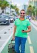 Mature man traveler with phone outdoor. Tourist traveler on spring vacation. Travelers luggage for spring trip. Summer tour. Tropical getaway. Spring break. A traveler enjoys summer day. Summer trip.