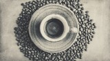 B&W top view of coffee cup on saucer surrounded by coffee beans on a neutral backdrop