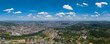 The city spans across the river under a bright sky, showcasing a vast urban landscape with buildings and green areas.