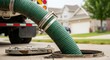 © Kristina - Suction hose extracting sewage from a septic tank. Septic pumping service and maintenance for home sanitation system.