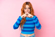 © luismolinero - Young caucasian woman isolated on pink background showing a sign of silence gesture