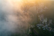 Mountain town vista with misty morning light casts over lake and buildings.