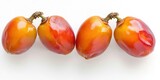 Four ripe persimmons are arranged in a row on a white surface. The persimmons display a gradient of colors, transitioning from a vibrant orange to a deeper red. 