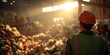 © Rifqi - A worker in safety gear observes a large pile of unsorted waste inside a recycling plant, concept for waste management, sustainable development and environmental awareness