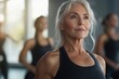 © Юлія Мельник - An older woman with gray hair is doing fitness in the gym, promoting an active lifestyle and longevity.