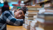 © Curioso.Photography - Tired student boy sleeping on books at a desk in a library aisle.