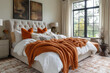 © kristina - Large bed with orange blankets in bedroom.