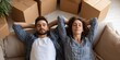 © Iryna - Couple relaxing on a couch amidst moving boxes in their new home
