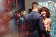 © AnnaStills - Teenage Caucasian girl smiling while dancing with teenage boy at formal event, holding hands and wearing corsage, standing in front of balloons and shimmering backdrop