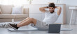 © Prostock-studio - Active lifestyle, social distancing and modern lockdown training online. Handsome millennial bearded arabian guy doing abs exercises in minimalist living room interior and looking at laptop on floor