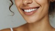 © Johannes - close up face of young woman with beautiful smile isolated on grey wall with copy space successful multiethnic girl latin woman looking at camera against gray wall with a big whitening teeth smile no