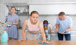 © JackF - Teenage girl actively participating in household chores by assisting family in cleaning apartment, wiping kitchen table. Concept of beneficial practice of involving teenagers in household chores